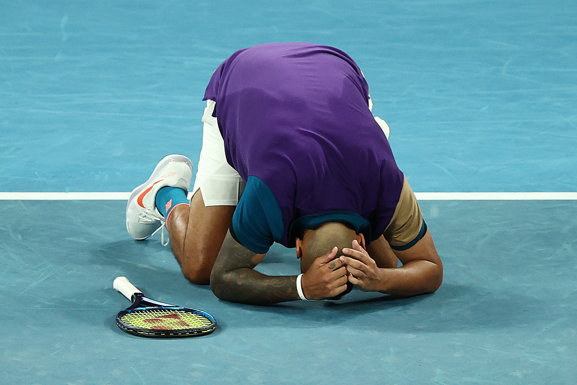 An emotional Nick Kyrgios collapses to the court after coming from behind to win in five sets ©Getty Images