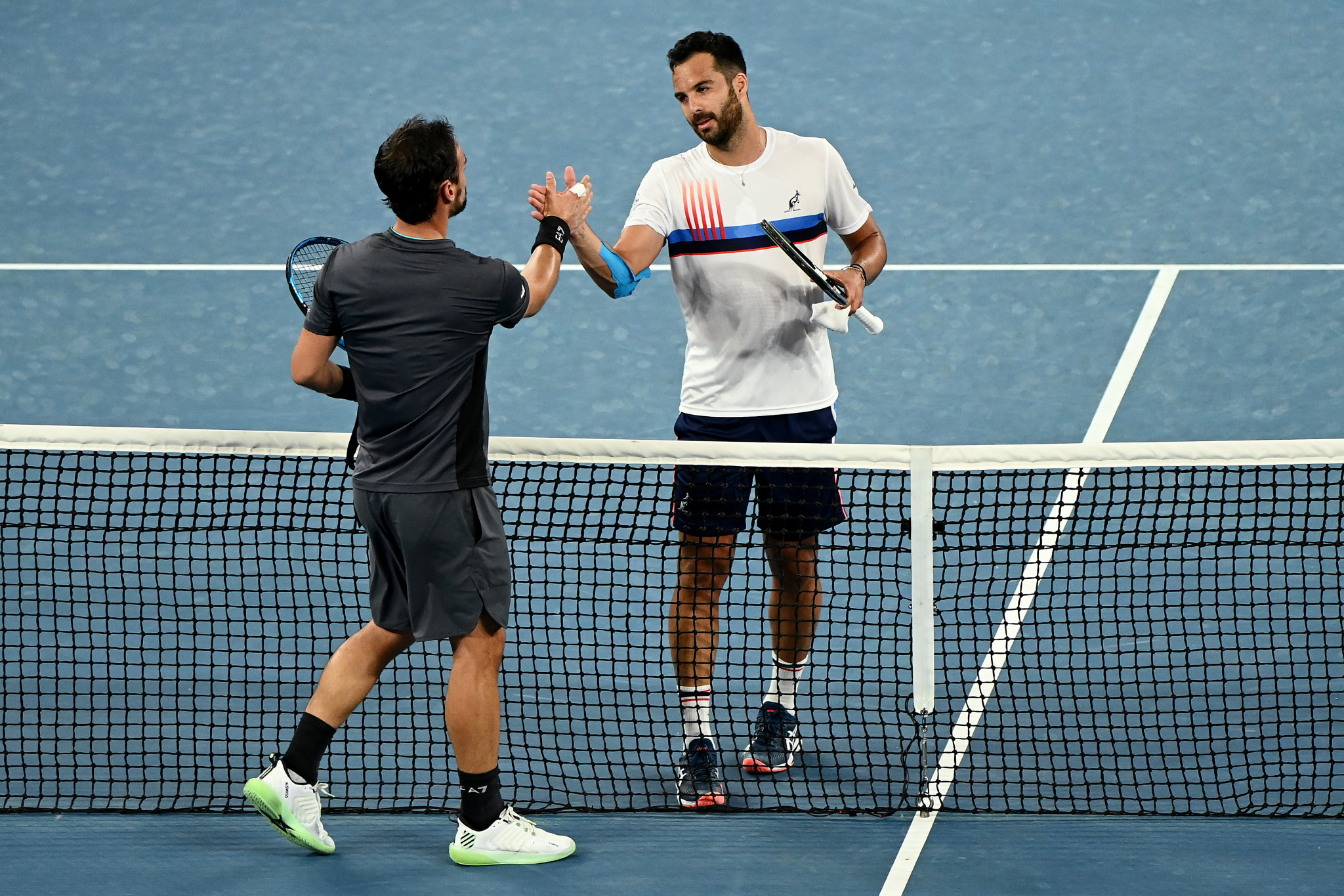 Italians Fabio Fognini and Salvatore Caruso (in white) embrace at the net following their match, shortly before the pair got involved in a heated exchange ©Getty Images