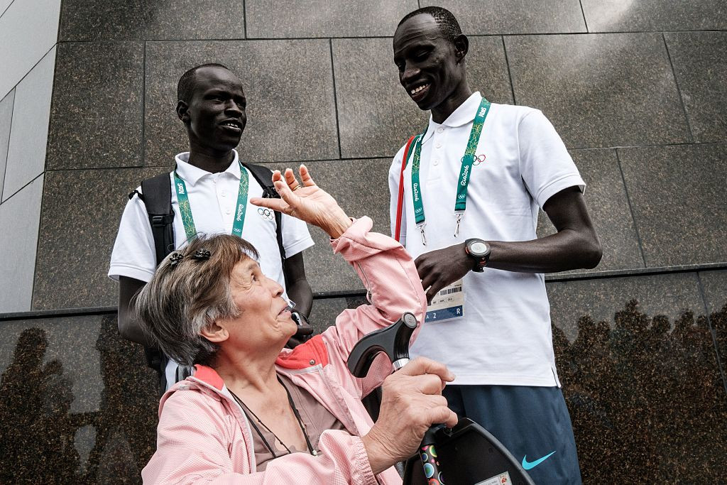 South Sudanese athletes James Nyang Chiengjiek, right, and Yiech Pur Biel, in Rio to compete in the 2016 Olympics for the Refugee Olympic Team, talk with a tourist at the statue of Christ the Redeemer ©Getty Images