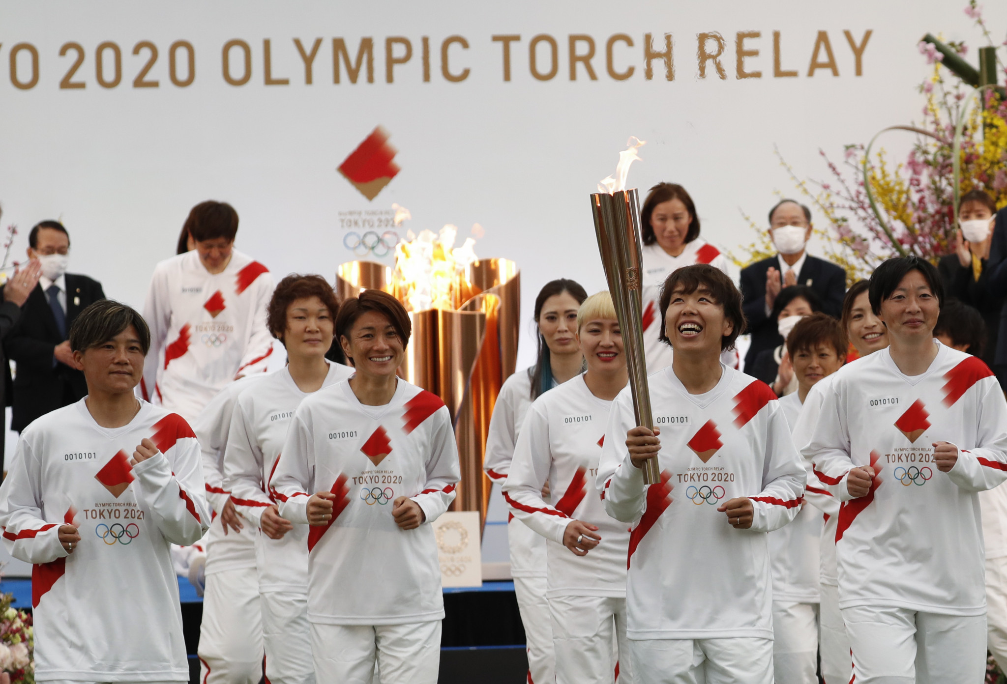 Azusa Iwashimizu was flanked by World Cup-winning team mates as she carried the Olympic Torch ©Getty Images