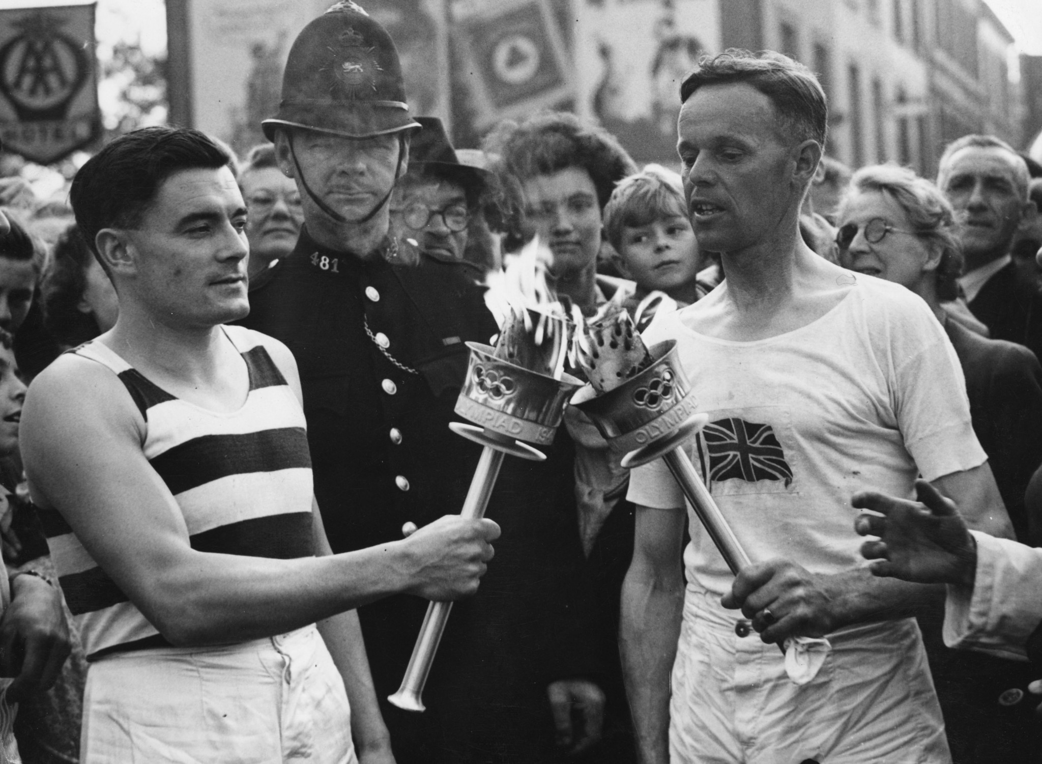 Veteran runner H J Bignall, right, hands the Olympic Torch to Fred Prevett at Redhill during the 1948 Relay from Dover to London ©Getty Images