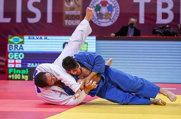 Gela Zaalishvili, in blue, brings down Brazilian giant Rafael Silva in the gold-medal match ©IJF