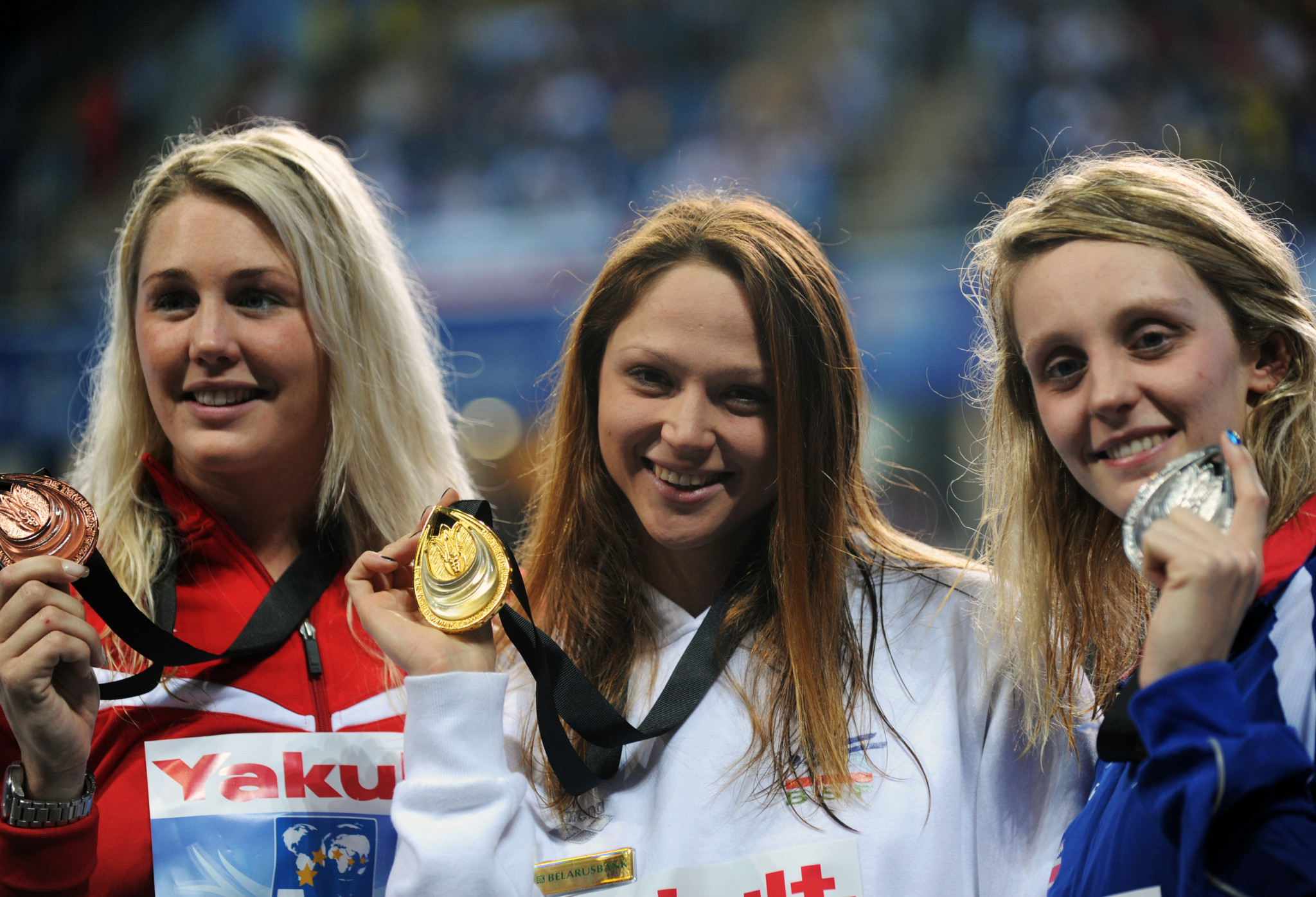 Aliaksandra Heresimenia, centre, with the 2012 World Championships Short Course gold medal that she is now putting up for sale  ©Getty Images