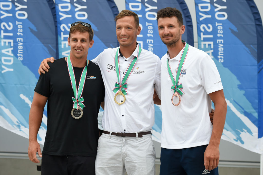 Hungary’s Zsombor Berecz, pictured centre after winning the Finn sailing Tokyo 2020 test event at Fujisawa in August 2019, is leader of the Championships after the first two races ©Getty Images