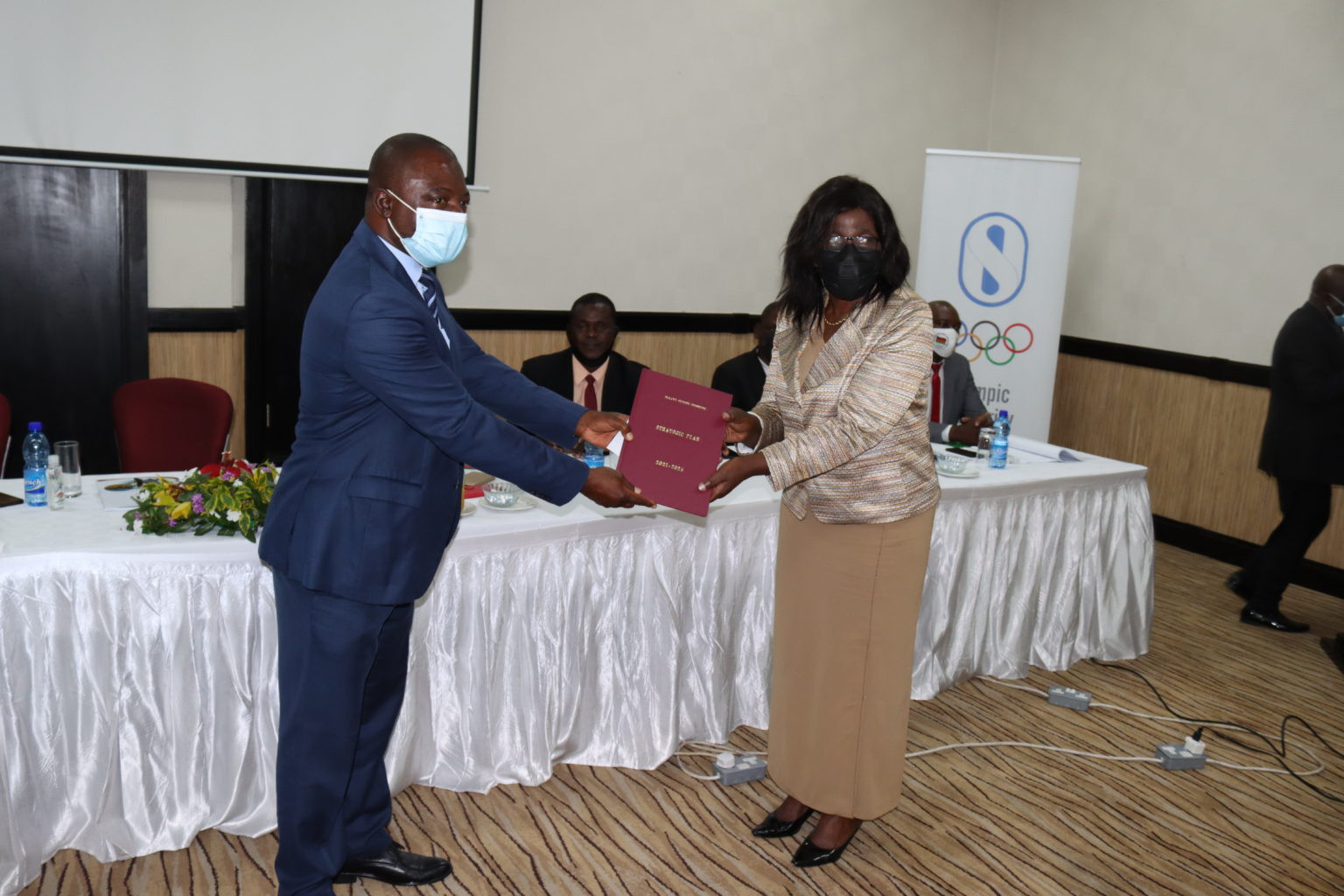 Jameson Ndalama, left, director of sports at the Ministry of Youth and Sports, poses with Malawi Olympic Committee vice-president Flora Mwandira and a copy of the strategic plan ©MOC