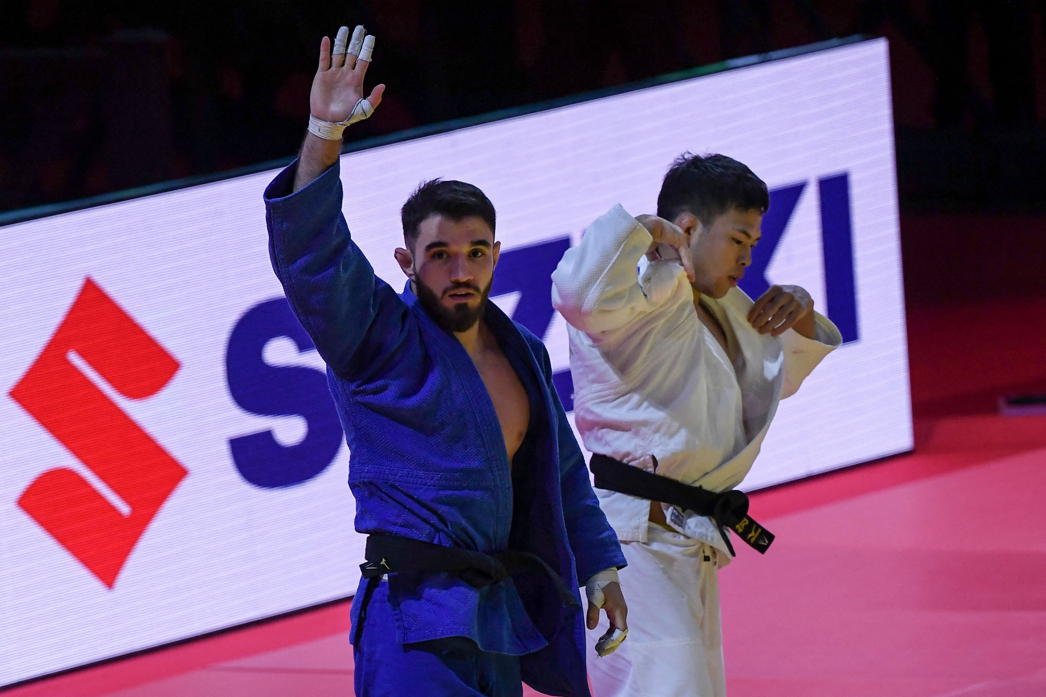 Karamat Huseynov, left, celebrates after his shock victory over men's under-60kg favourite Ryuju Nagayama ©Getty Images