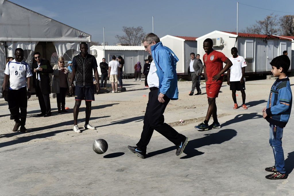Thomas Bach playing football with youngsters at the Elaionas refugee camp ©Getty Images