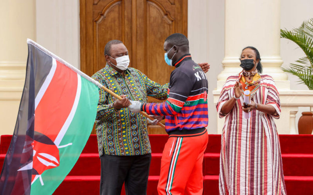 Andrew Amonde receives the Kenyan flag from President Uhuru Kenyatta ©NOCK