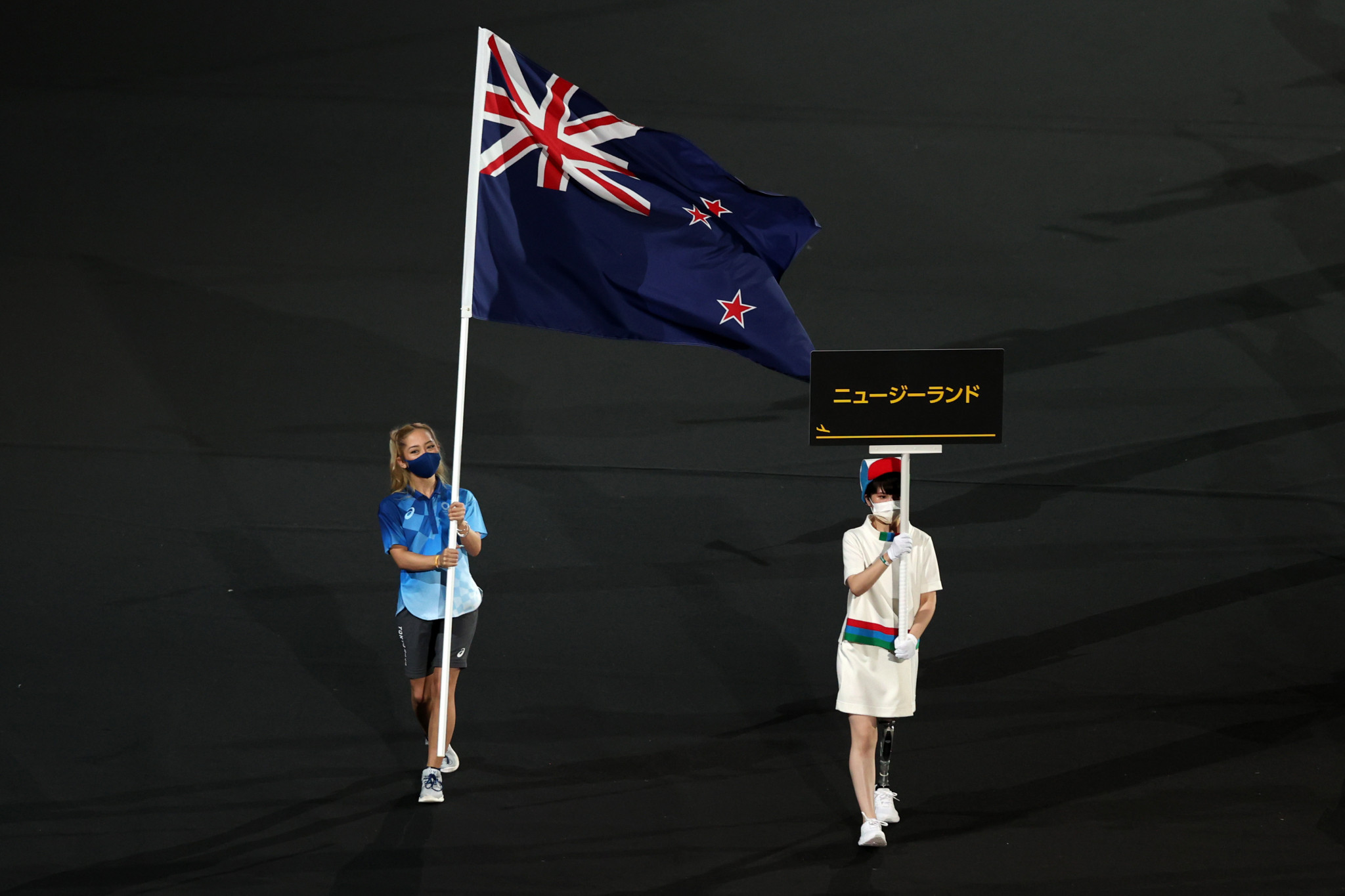 A Tokyo 2020 volunteer carries the flag of New Zealand after the team opted to miss the Opening Ceremony over COVID-19 concerns ©Getty Images
