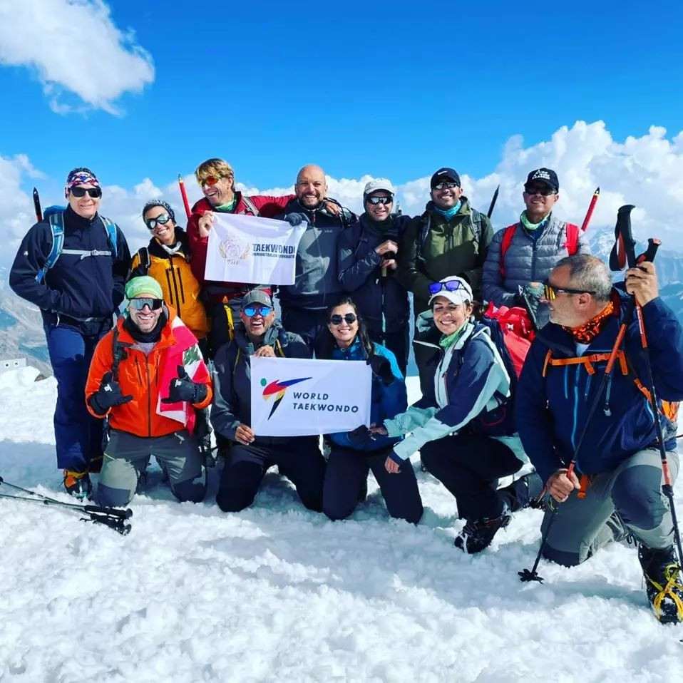 Farah Al Asa'ad, centre, bottom row, made it to the top of Mount Elbrus with the World Taekwondo and Taekwondo Humanitarian Foundation flags ©Farah Al Asa'ad/THF