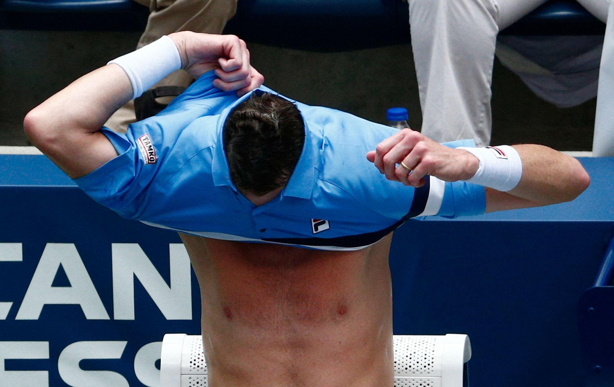 John Isner of the United States changes shirts during his defeat to compatriot Brandon Nakashima ©Getty Images