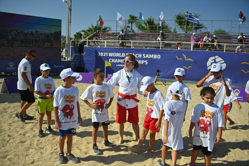 French fighter Laure Fournier, centre, led the training session for children in Larnaca before the World Beach Sambo Championships ©FIAS