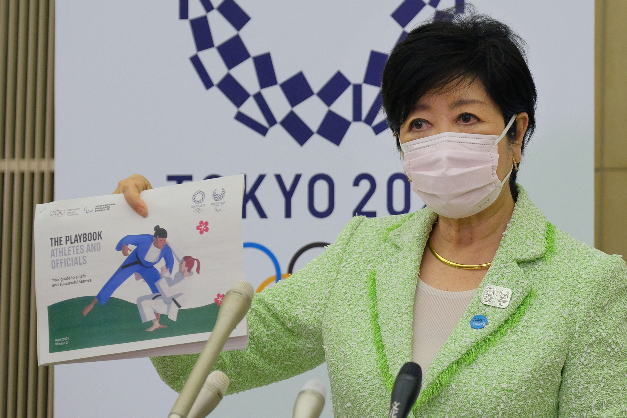 Tokyo Governor Yuriko Koike shows one of the Tokyo 2020 playbooks which outlined organisers' COVID-19 countermeasures ©Getty Images