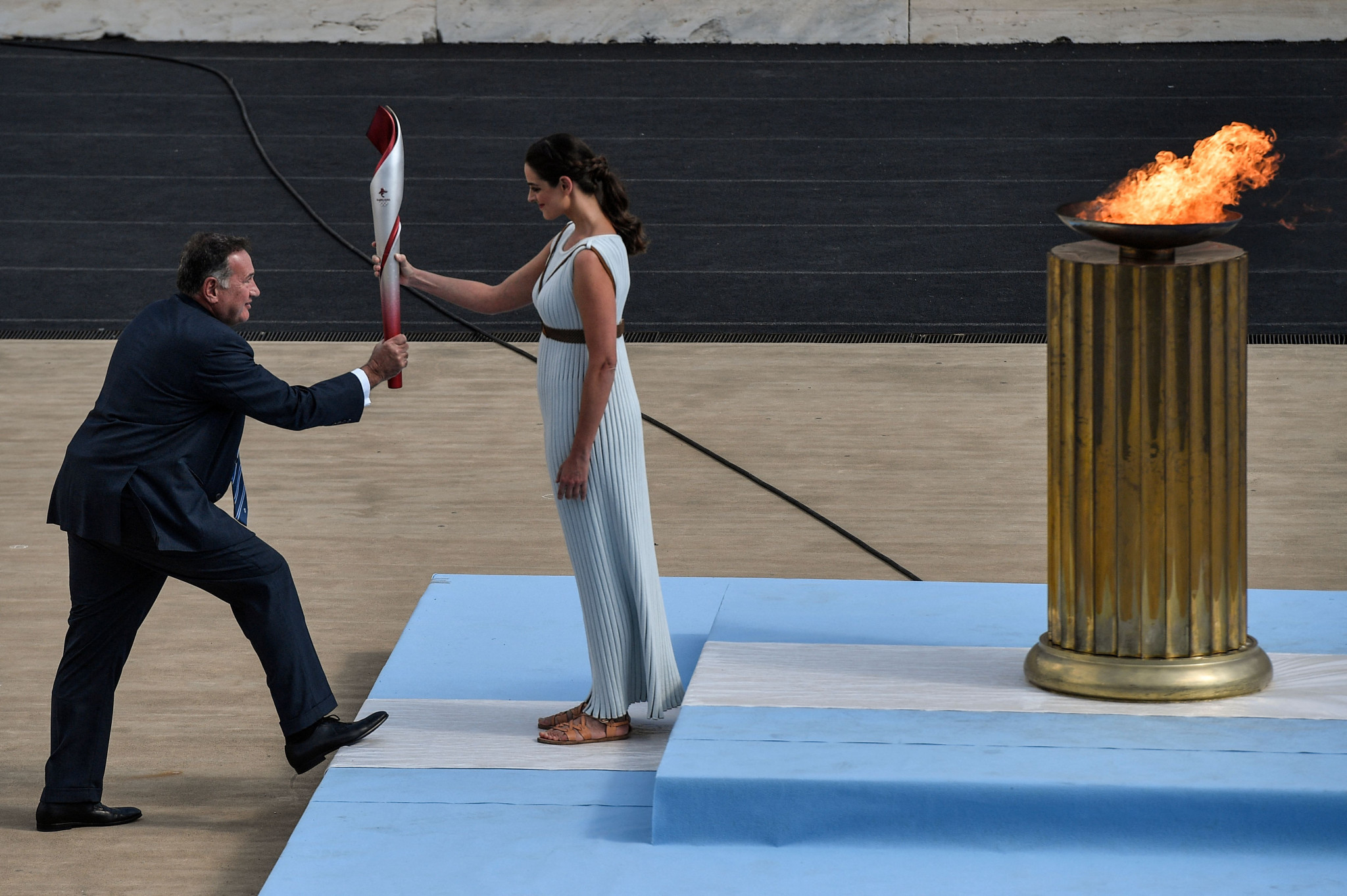 High Priestess Xanthi Georgiou passes the Olympic Flame to Hellenic Olympic Committee President Spyros Capralos ©Getty Images 