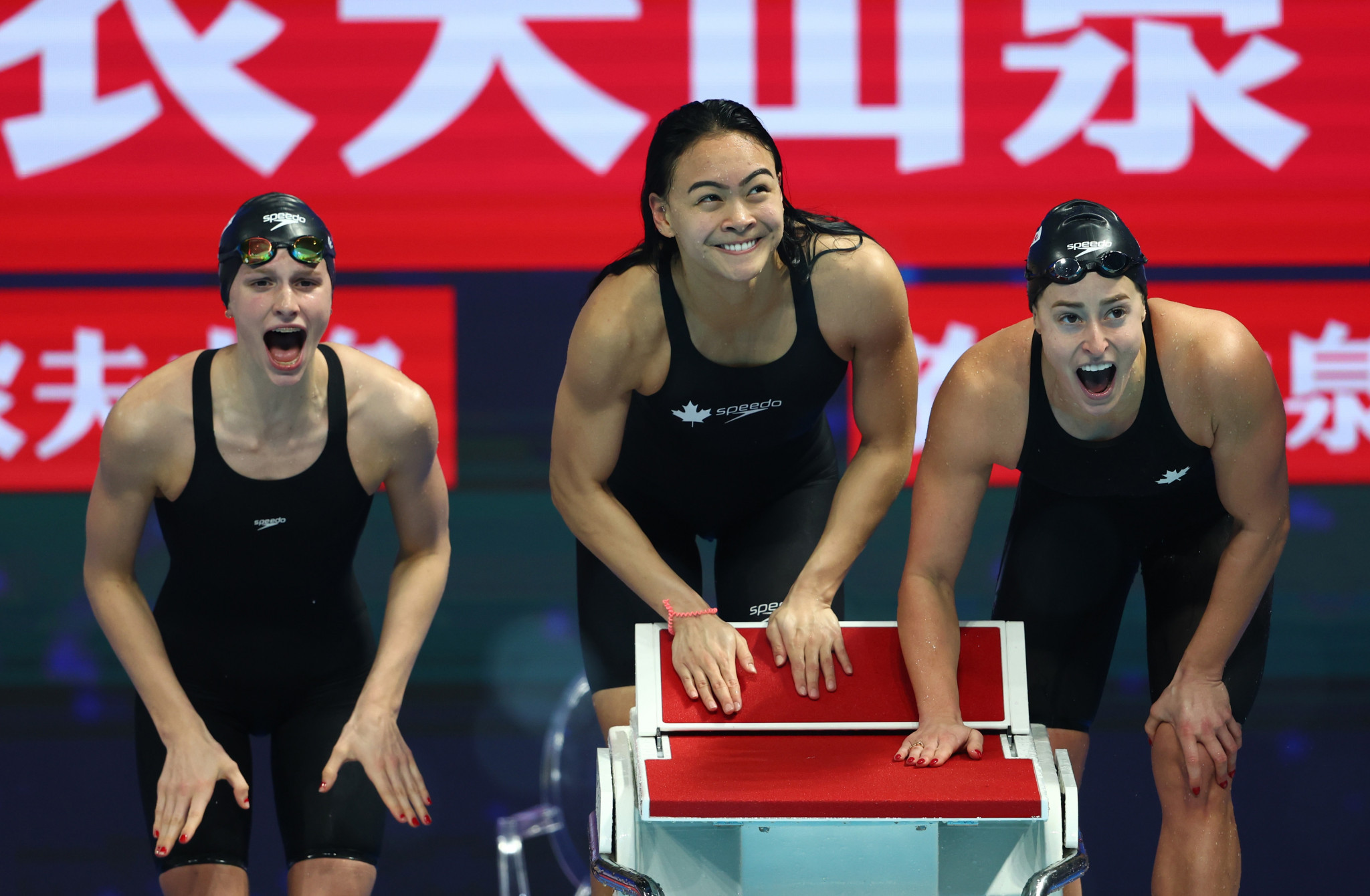Summer MacIntosh, Kayla Sanchez and Katerine Savard cheer on Canadian teammate Rebecca Smith in the women's 4x200m freestyle relay final ©Getty Images
