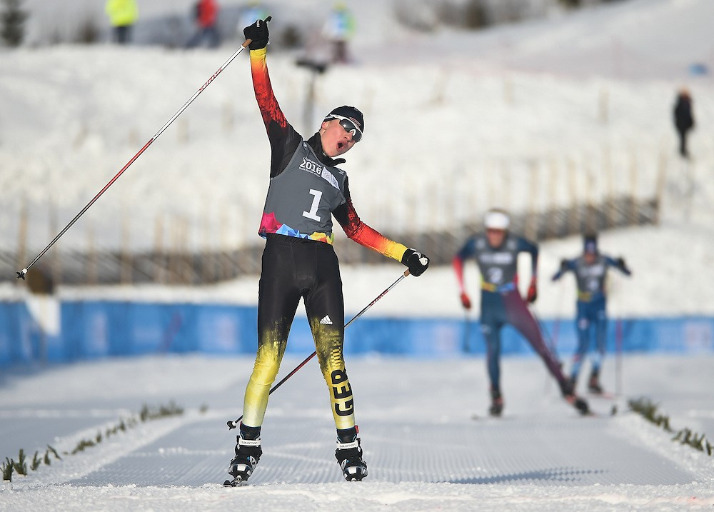 Tim Kopp celebrates as he crosses the line in first place to take men's Nordic Combined gold ©YIS/IOC