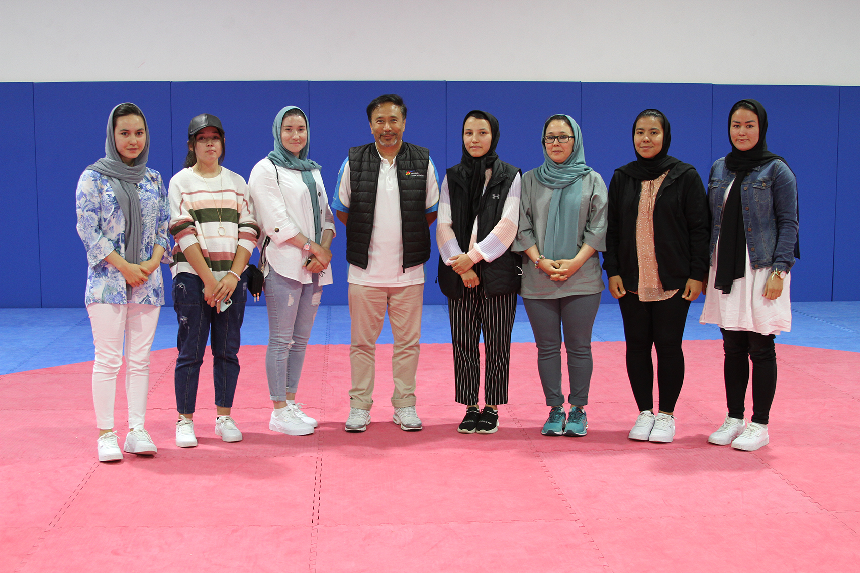 Melbourne-based taekwondo instructor Ali Rahimi poses with the eight female athletes he helped escape from Afghanistan after the Taliban Government took control in Kabul ©Australia Taekwondo 