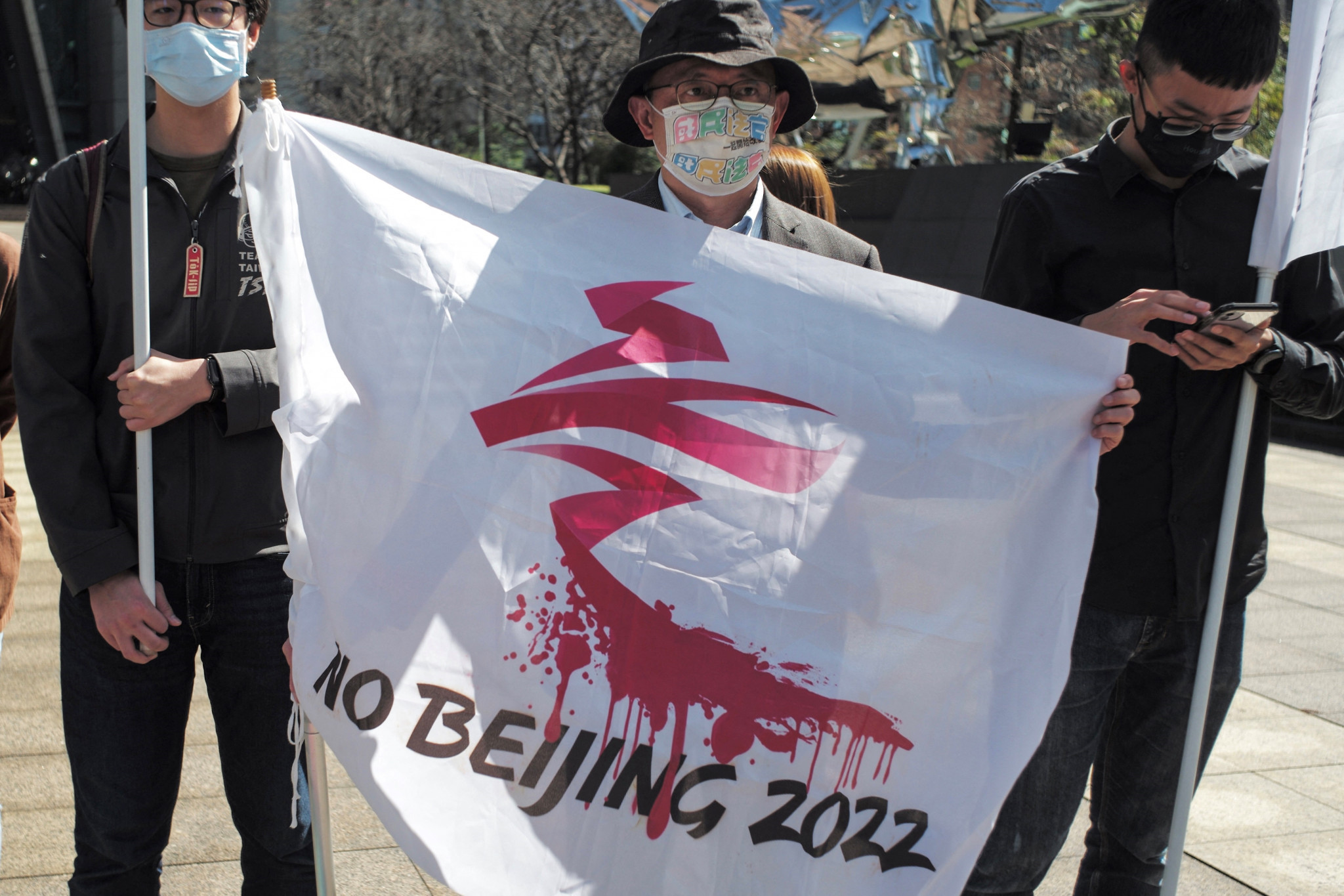 An activist holds a banner to protest against the Winter Olympics in Beijing during a demonstration outside the Bank of China in Taipei ©Getty Images