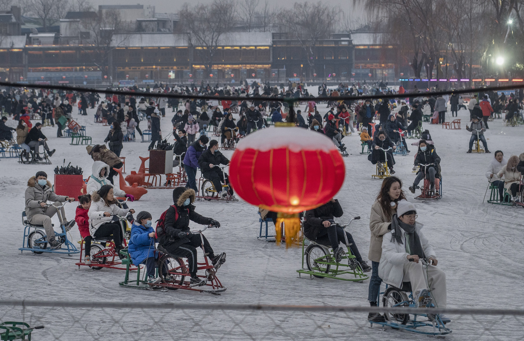 People ride ice bikes and ice chairs as they enjoy an outdoor rink on Shichahai Lake in Houhai ©Getty Images