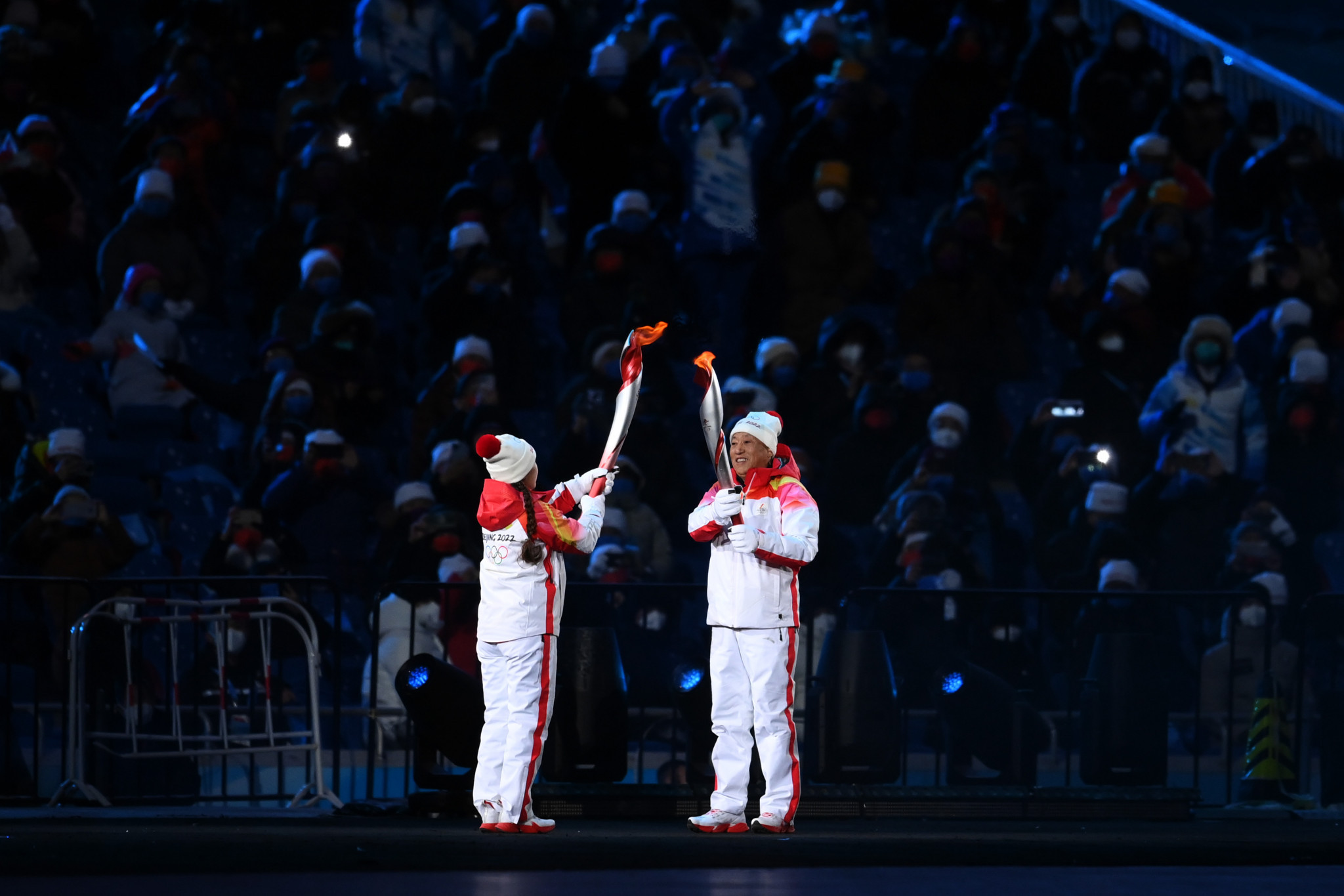 Uyghur cross-country skier Dinigeer Yilamujiang and Nordic combined competitor Zhao Jiawen placed the Olympic Torch on a receptacle to complete the Olympic Torch Relay ©Getty Images 