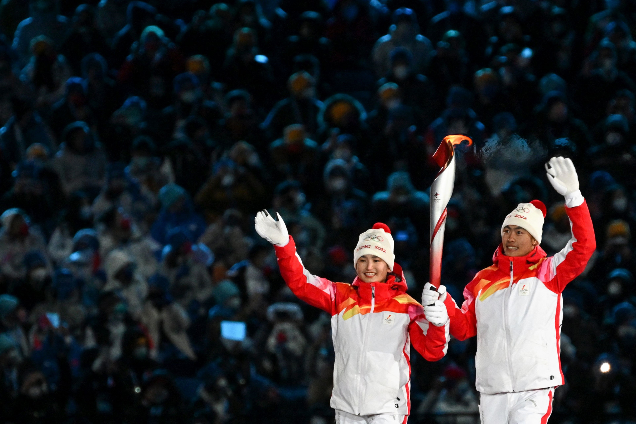 Dinigeer Yilamujiang, left,  Zhao Jiawen hold the Olympic flame during the Opening Ceremony ©Getty Images