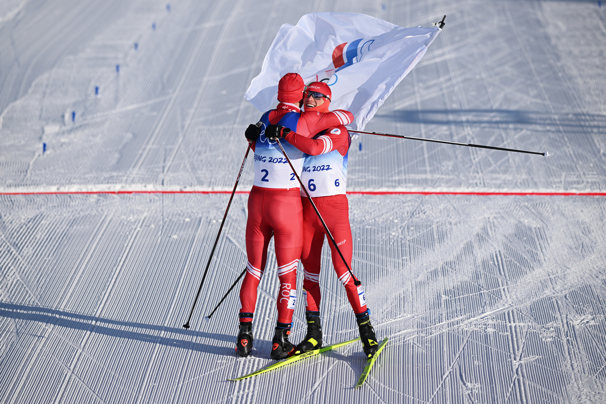 Denis Spitsov, right, embraces compatriot Alexander Bolshunov after the pair finished second and first respectively in the men's 30 kilometres skiathlon at Beijing 2022 ©Getty Images 
