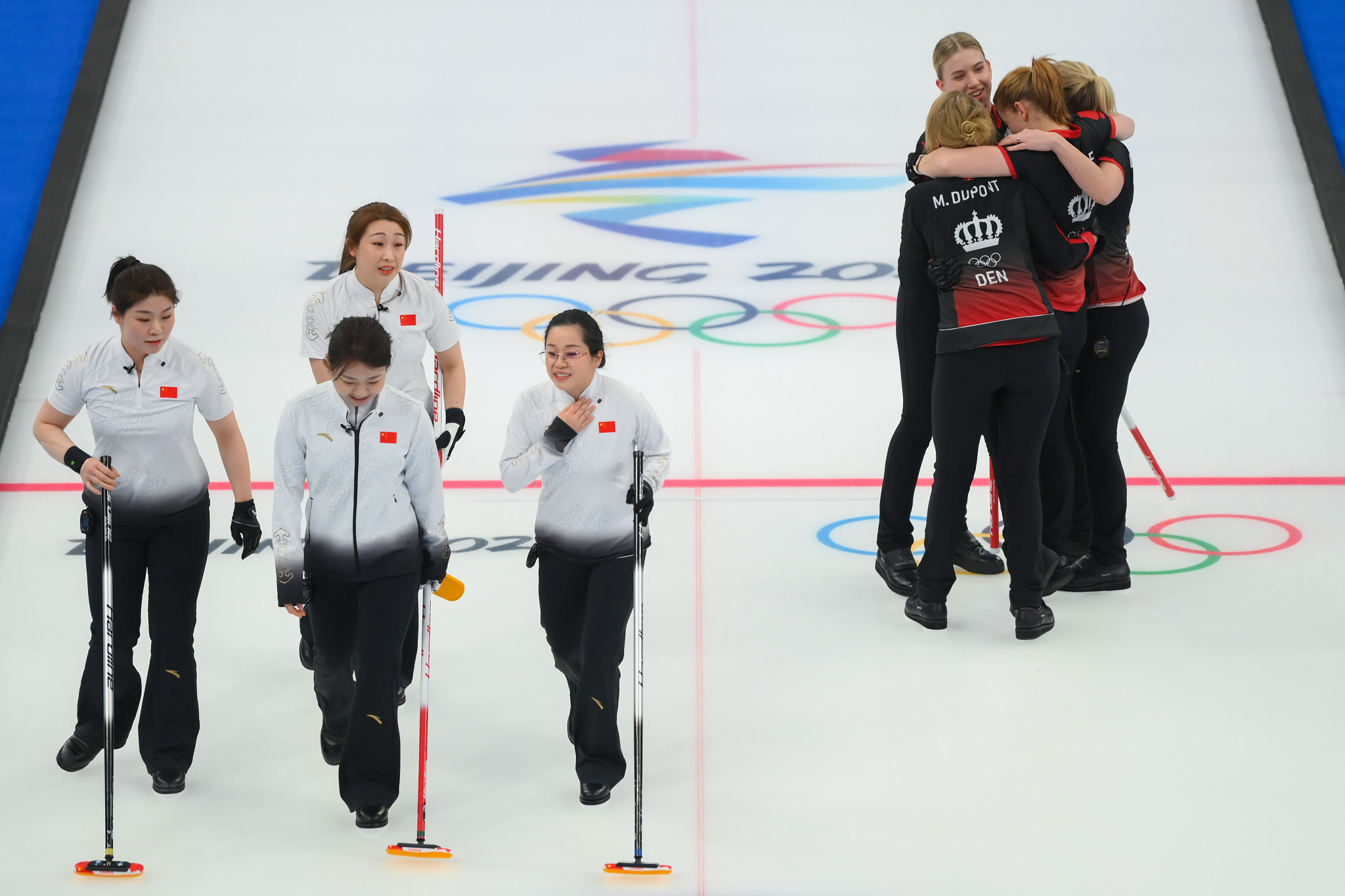 Denmark players, right, celebrate after beating China in the women's curling round robin match ©Getty Images