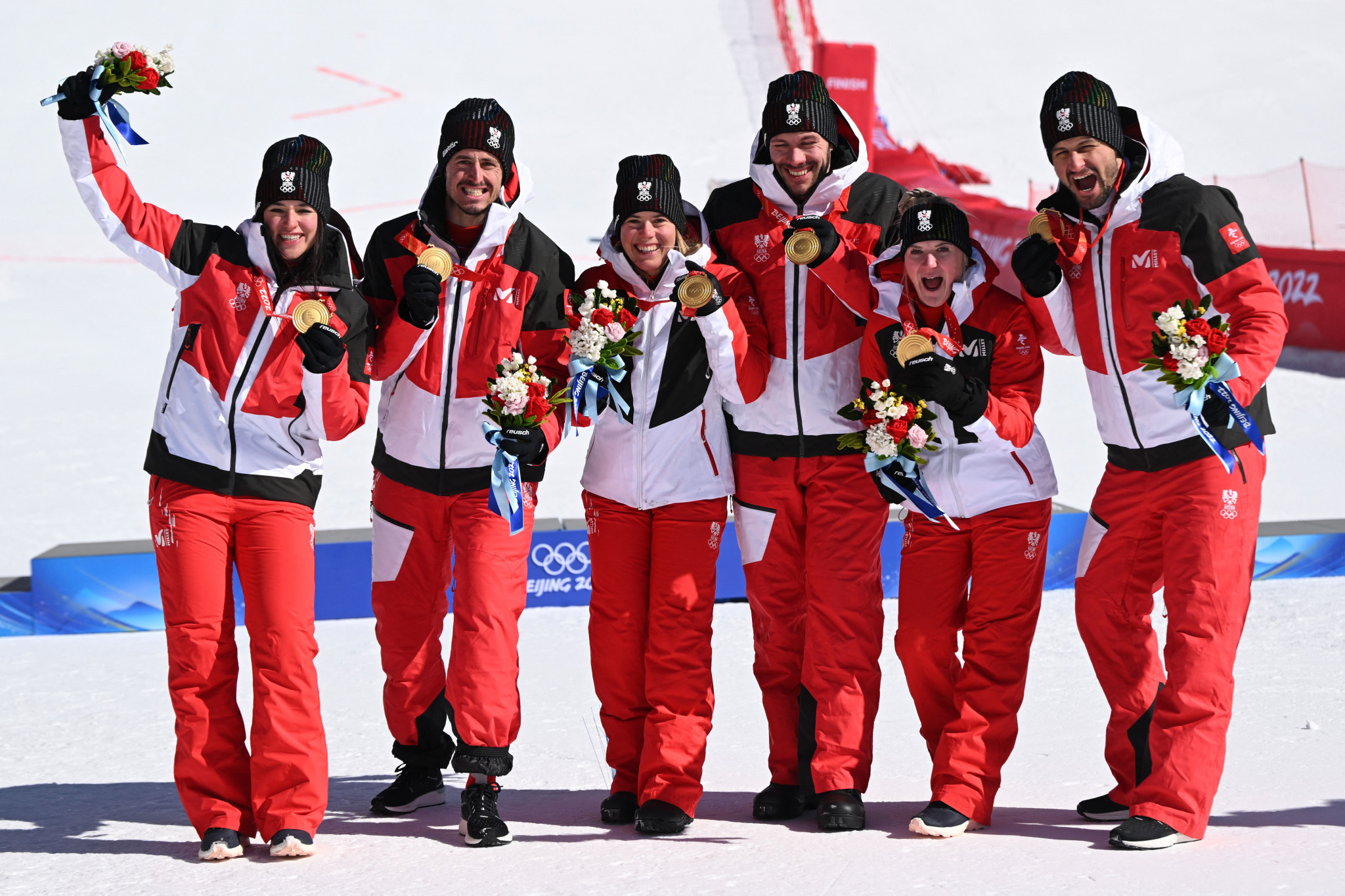 Johannes Strolz, right, celebrates with his Austrian team-mates after claiming mixed team parallel gold at Beijing 2022 ©Getty Images