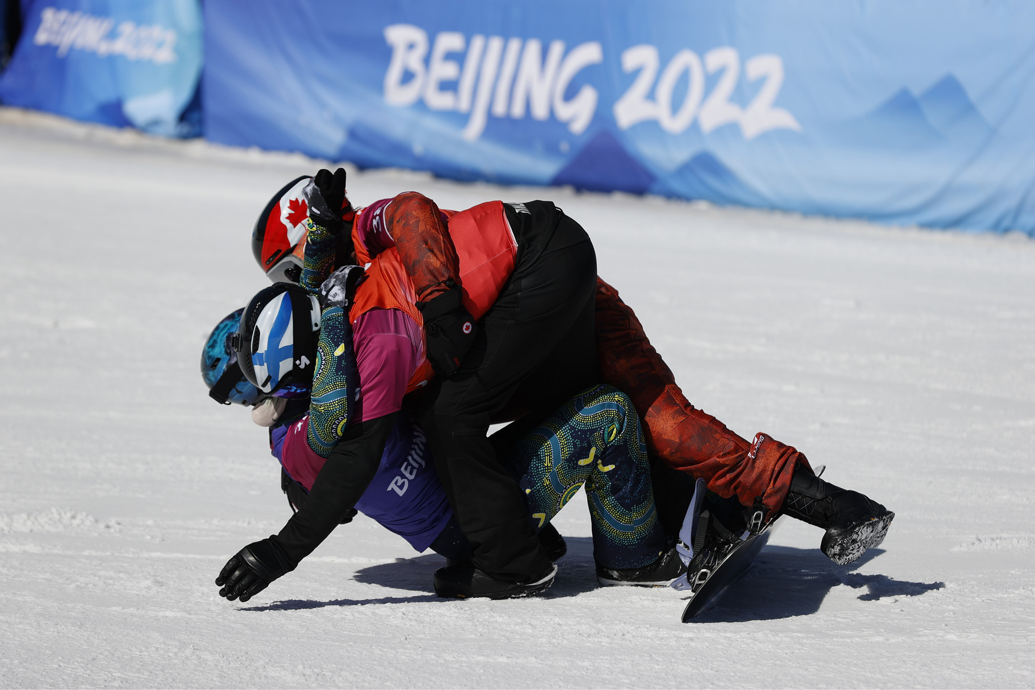 Finland's Matti-Suur Hamari, Australian Ben Tudhope and Canada's Alex Massie embraced after the men's snowboard cross in their special helmets ©Getty Images