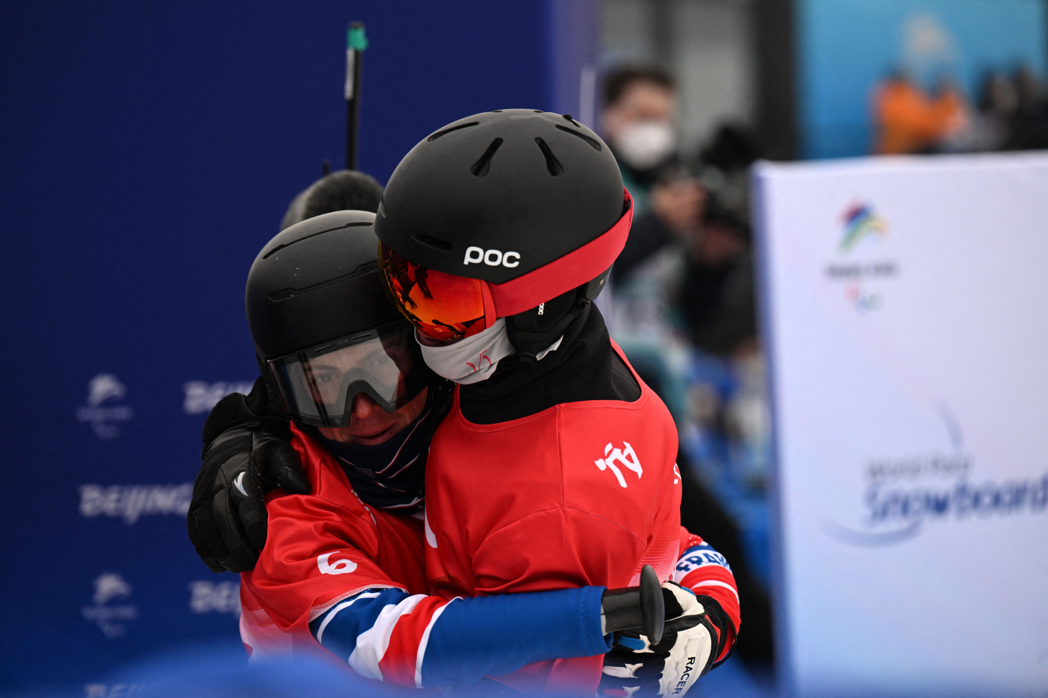 France's Maxime Montaggioni, left, embracing China's Ji Lijia, right, after winning gold and silver respectively in the men's snowboard banked slalom SB-UL ©Getty Images