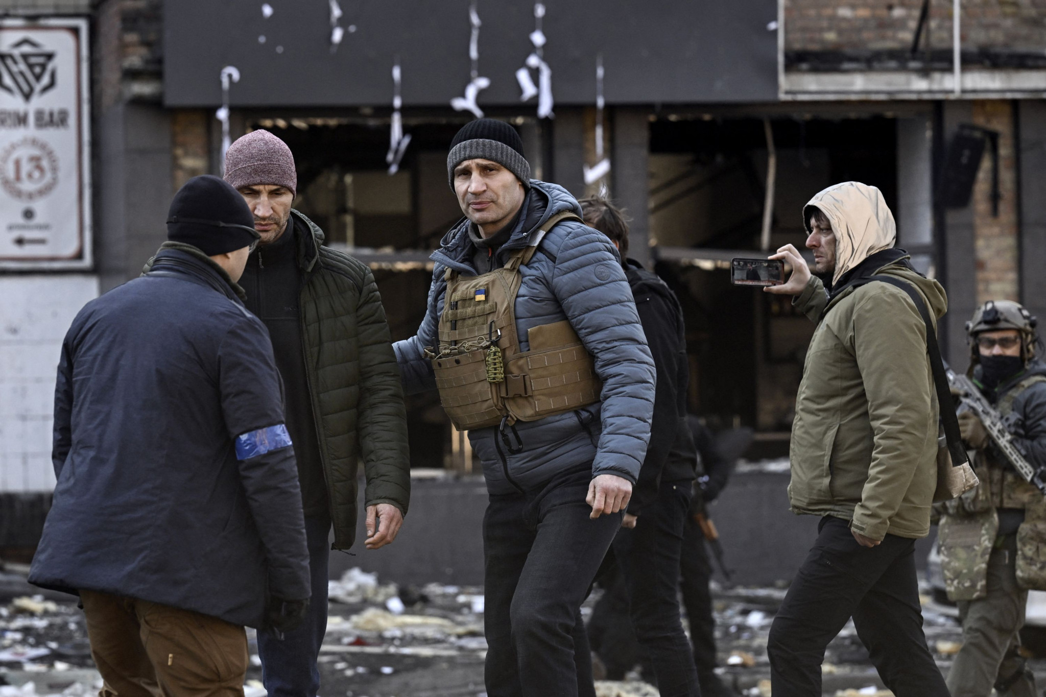 Kyiv's mayor Vitali Klitschko, centre, walks next to his brother Wladimir, second from left, in front of a destroyed apartment building, in Kyiv following the Russian invasion of Ukraine ©Getty Images