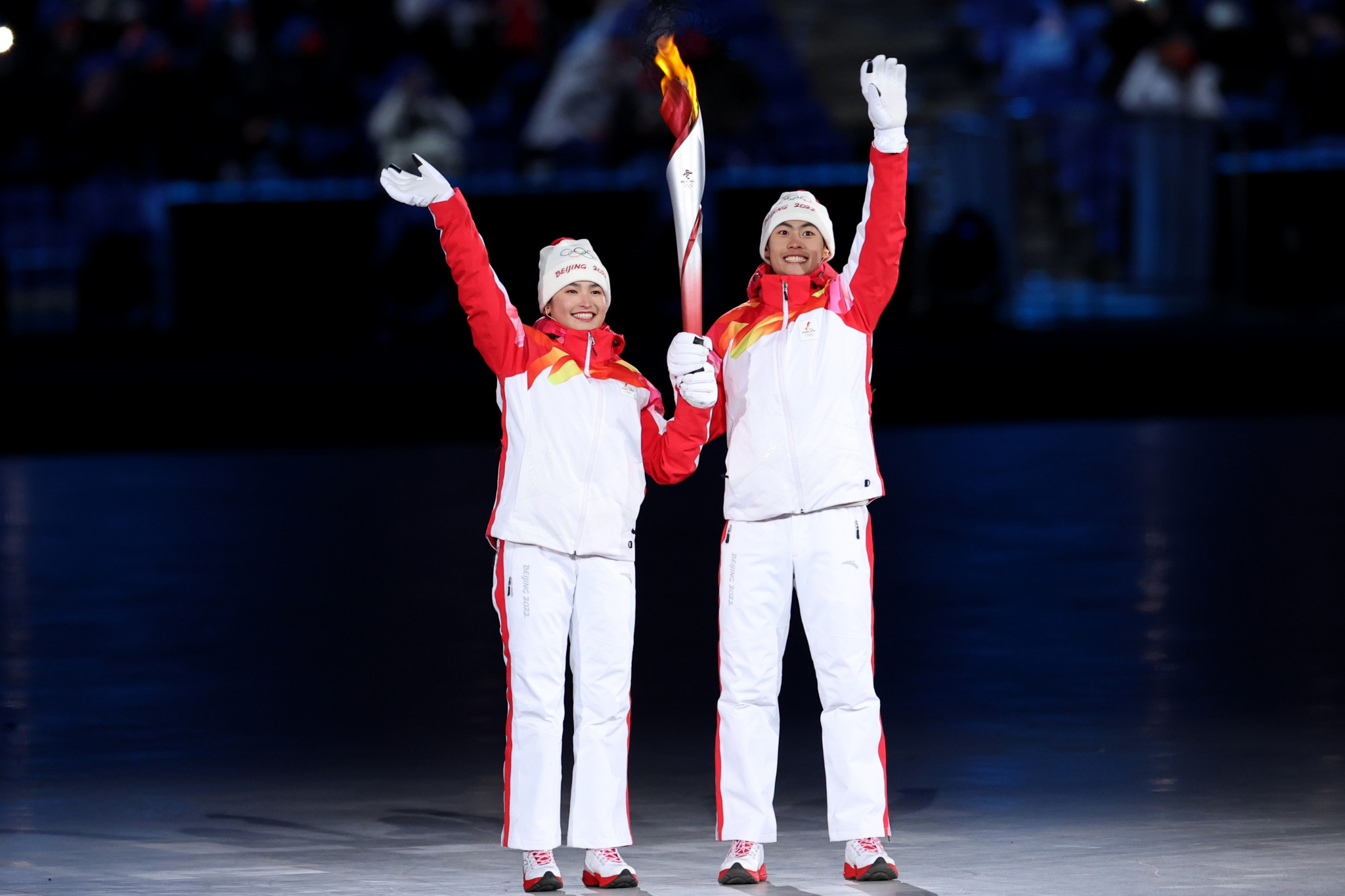 Dinigeer Yilamujiang, left, holds the Olympic Torch with Zhao Jiawen before lighting the Cauldron ©Getty Images