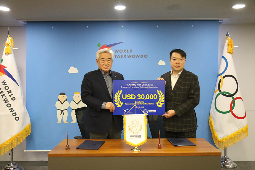 THF chairman Chungwon Choue, left, received a donation from the Hong Kong Taekwondo Association President to assist refugees ©World Taekwondo 