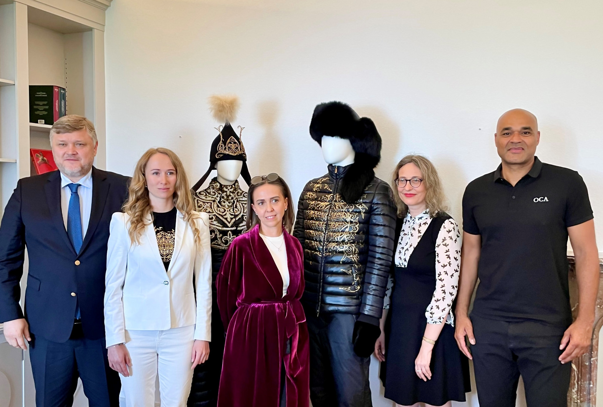 Kazakhstan NOC secretary general Andrey Kryukov, left, speed skater Yekaterina Aidova, second left, and designer Violetta Ivanova, centre, are pictured next to the costumes at the Olympic Museum ©Kazakhstan NOC