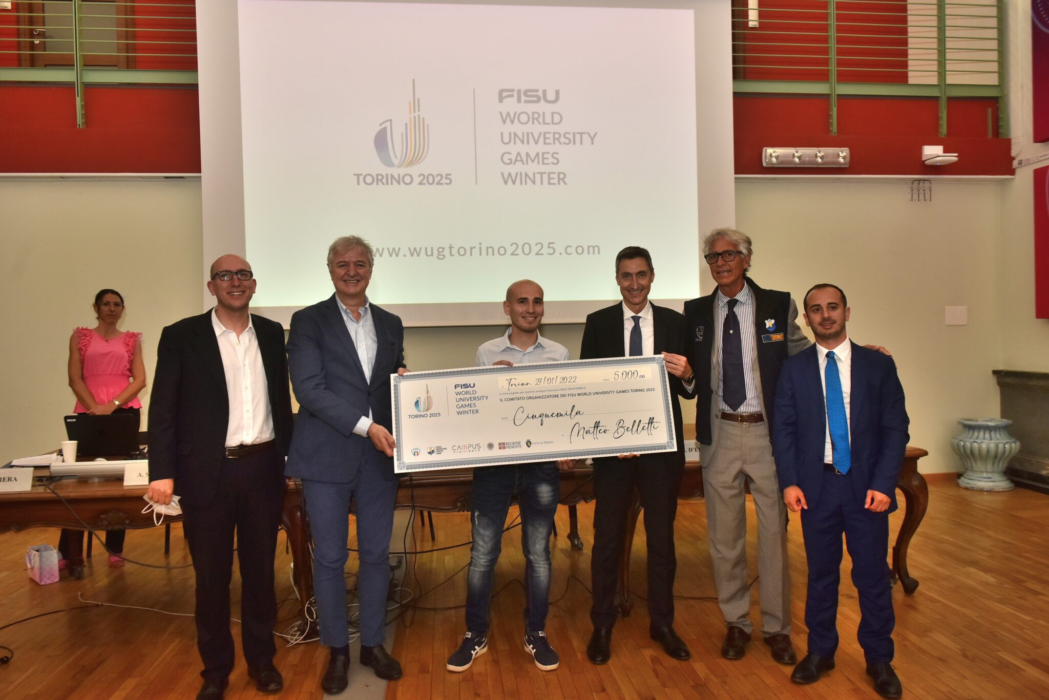 Turin 2025 logo designer presented with prize cheque