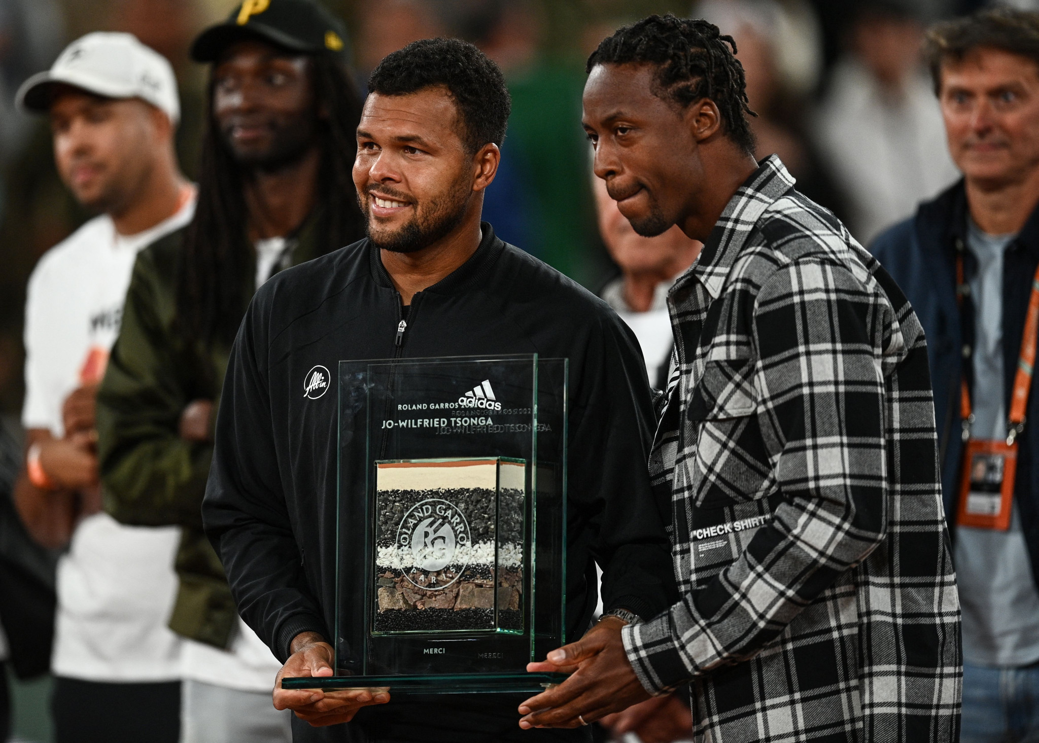 Jo-Wilfried Tsonga, left, poses with Gael Monfils after receiving a trophy to mark his retirement ©Getty Images