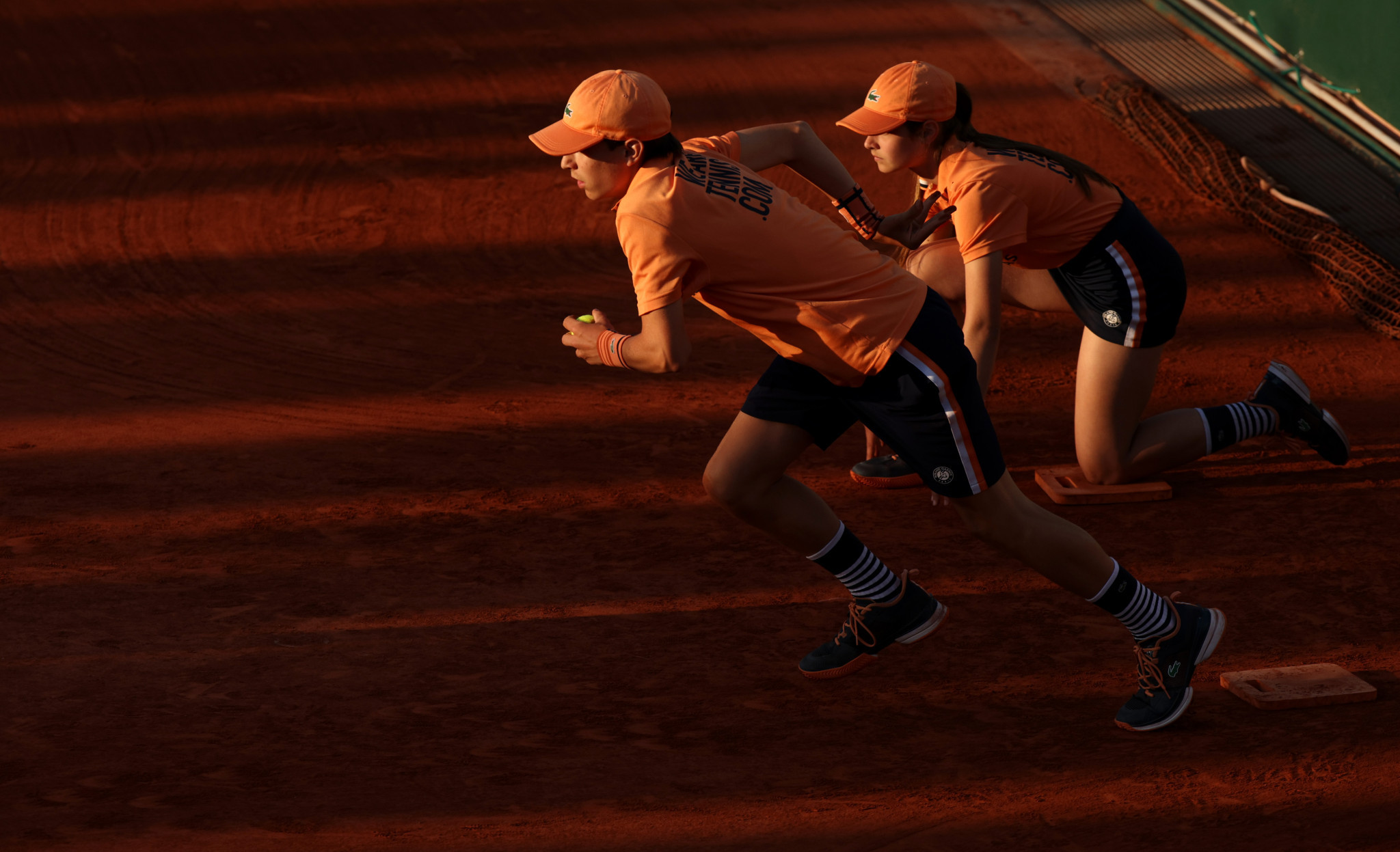 Ballkids in action as the sun sets over Roland Garros on day seven of the French Open ©Getty Images