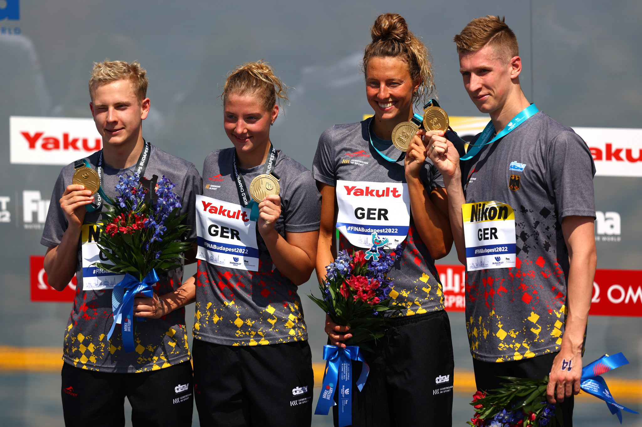 Oliver Klemet, furthest left, Leo Boy, second left, Leonie Beck, second right, and Florian Wellbrock, furthest right, claimed the first open water swimming gold medal of the FINA World Championships for Germany ©Getty Images