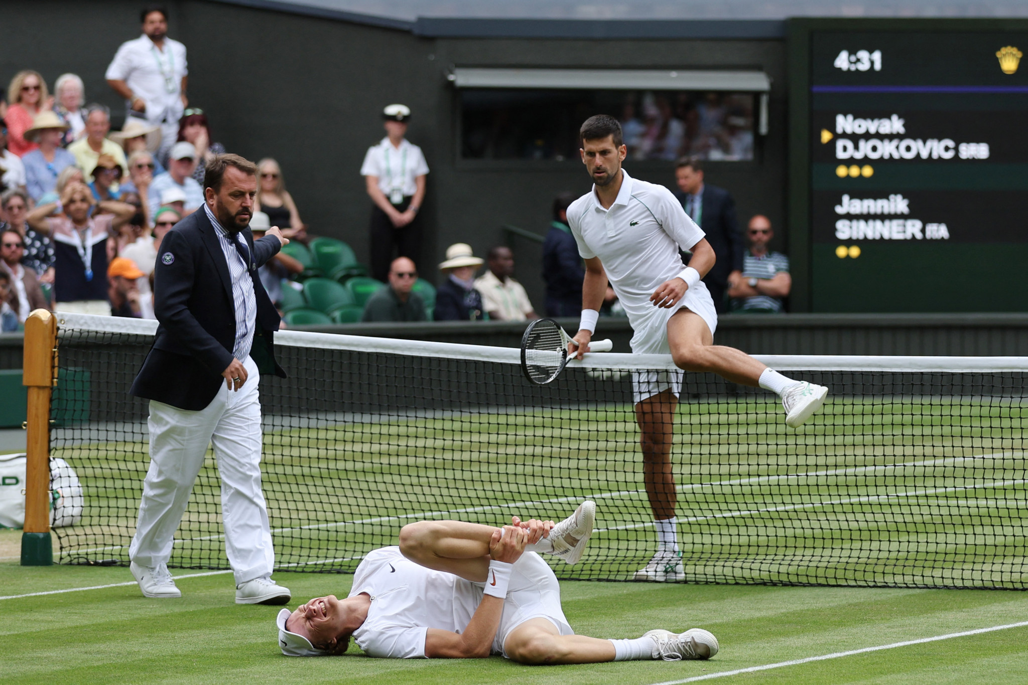 Novak Djokovic checking on Jannik Sinner after his opponent went down with an injury ©Getty Images
