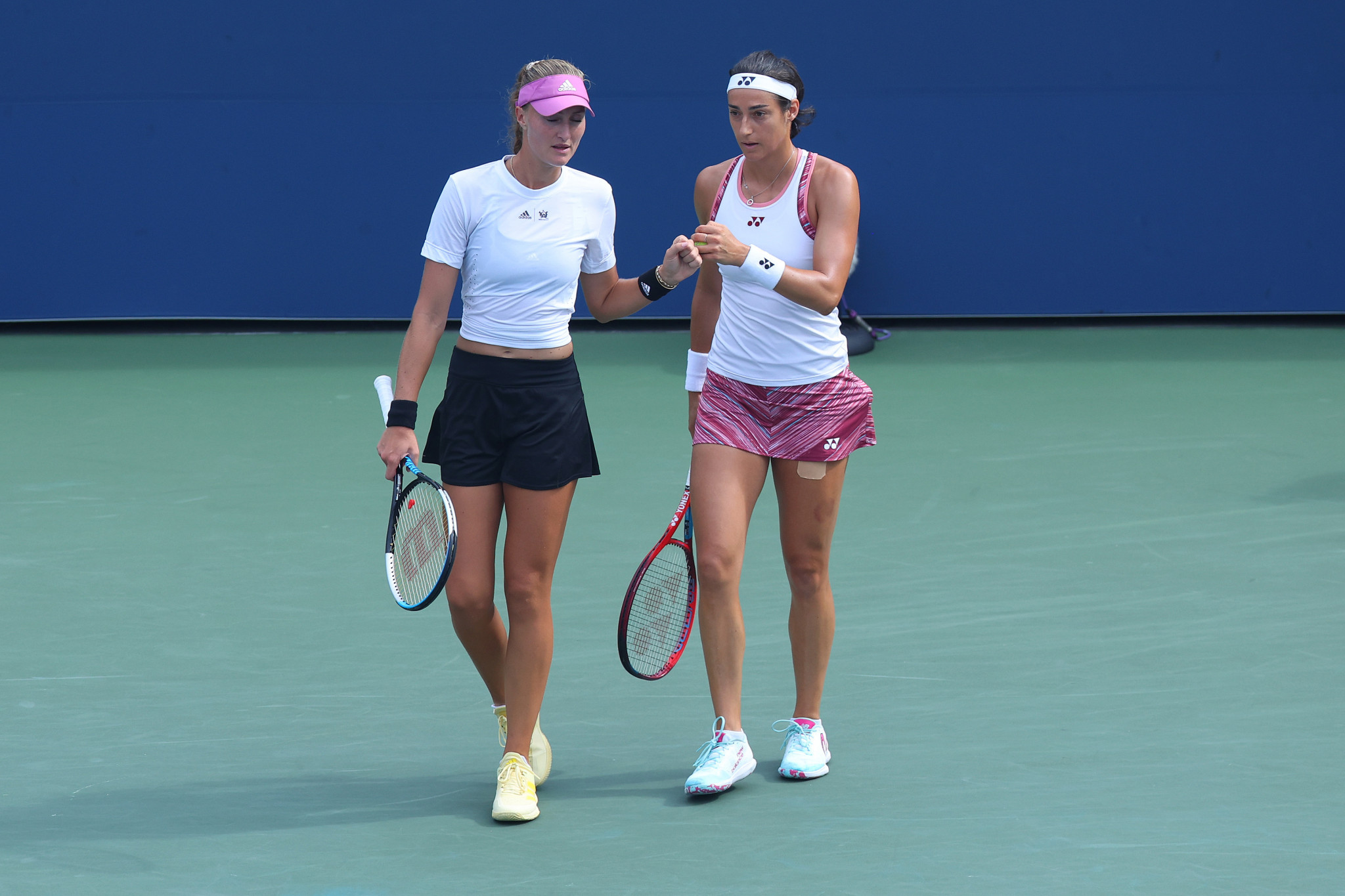 Kristina Mladenovic, left, and Caroline Garcia talk tactics during their women's doubles third-round match ©Getty Images