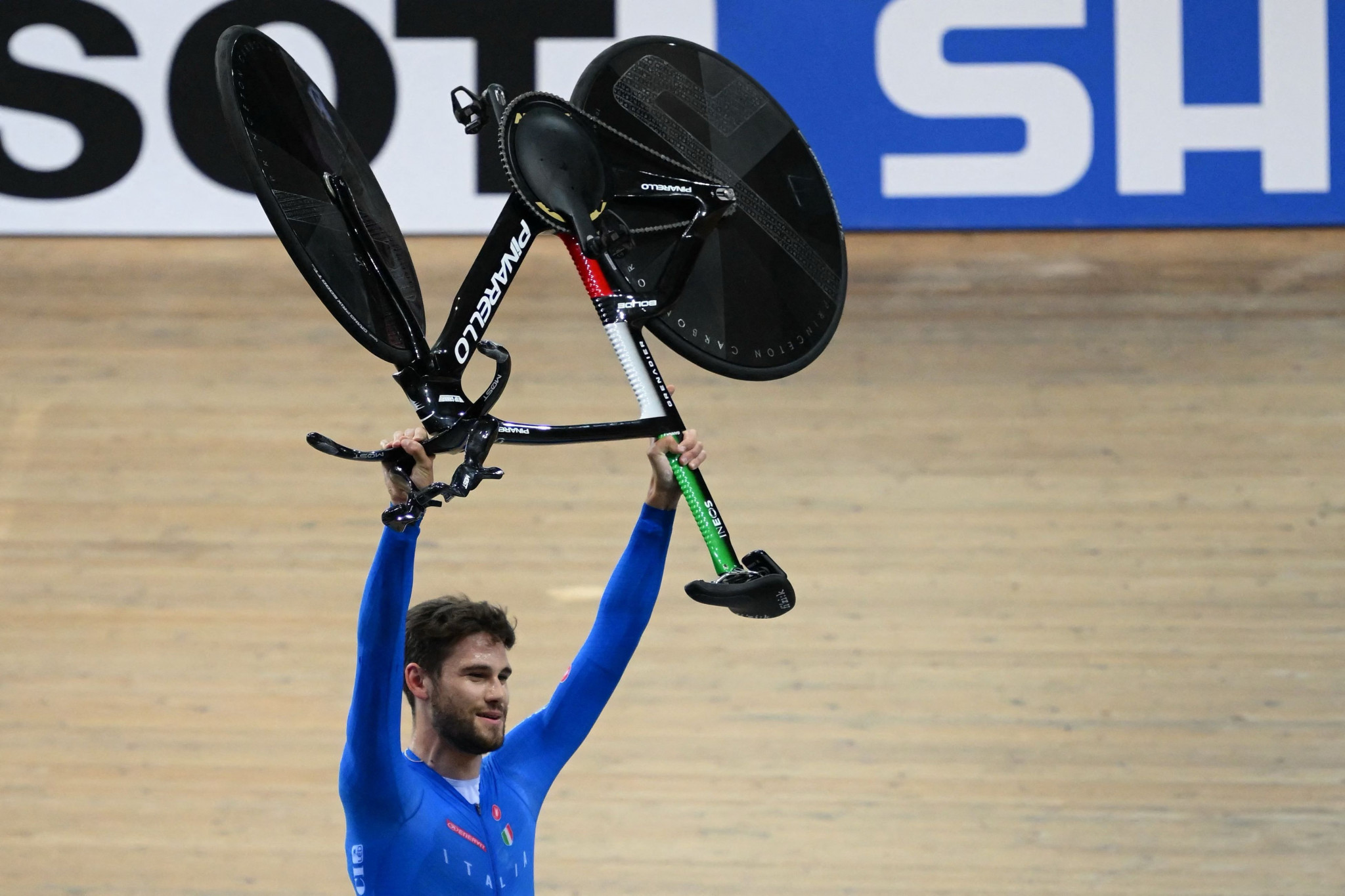 Filippo Ganna lifts his bike in triumph after setting a world record in winning the men's individual pursuit ©Getty Images