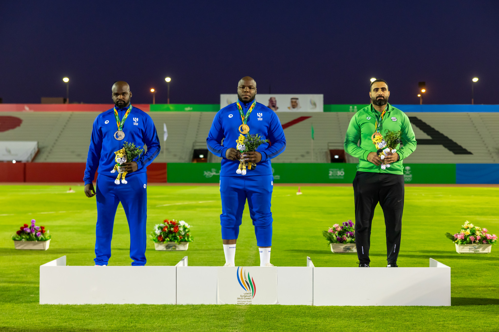 Mohammed Tolo won the men's discus with Abo Baker Zakaria, left and Osama Al-Oqaili, right, joining him ©Saudi Games