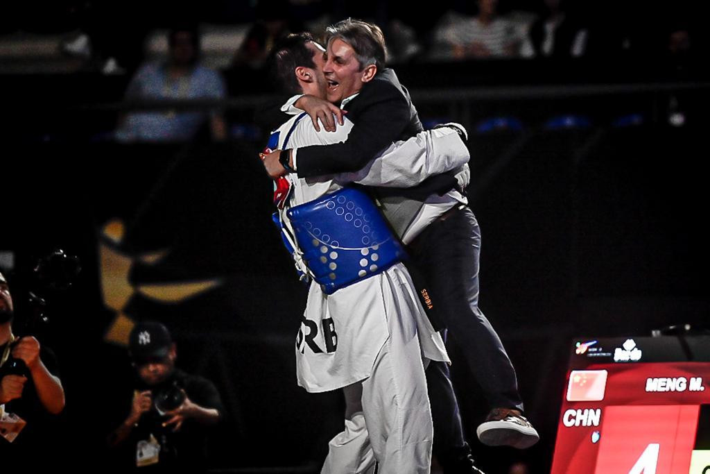 Khodabakhshi celebrates with his coach after capturing his second world title ©World Taekwondo