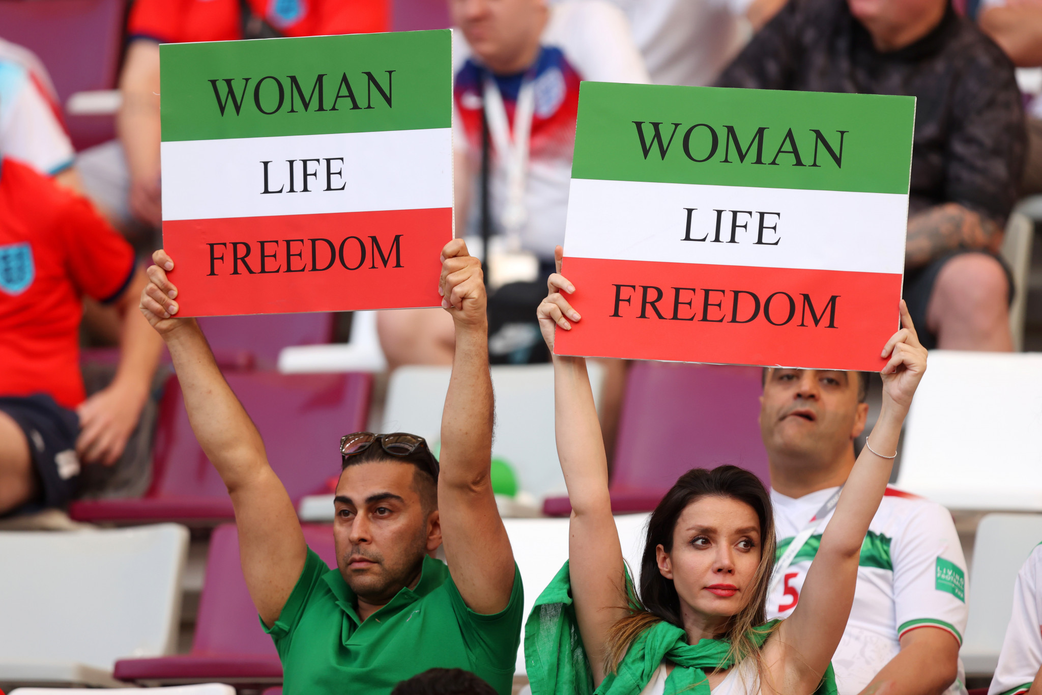 Iranian supporters hold banners saying 