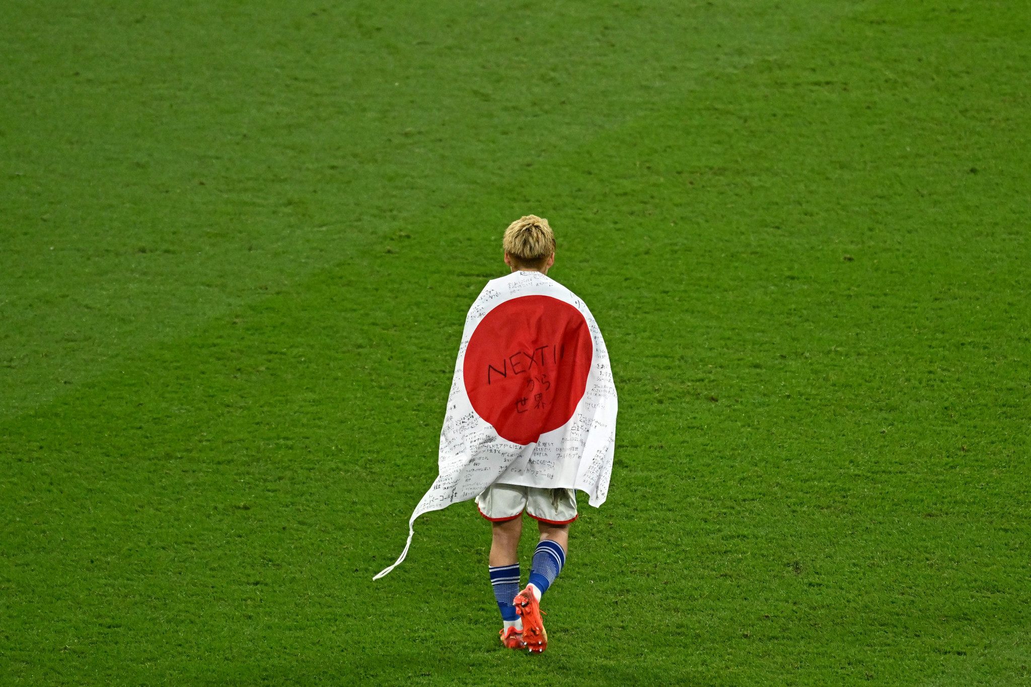 Ritsu Doan draping himself in the flag after the match ©Getty Images