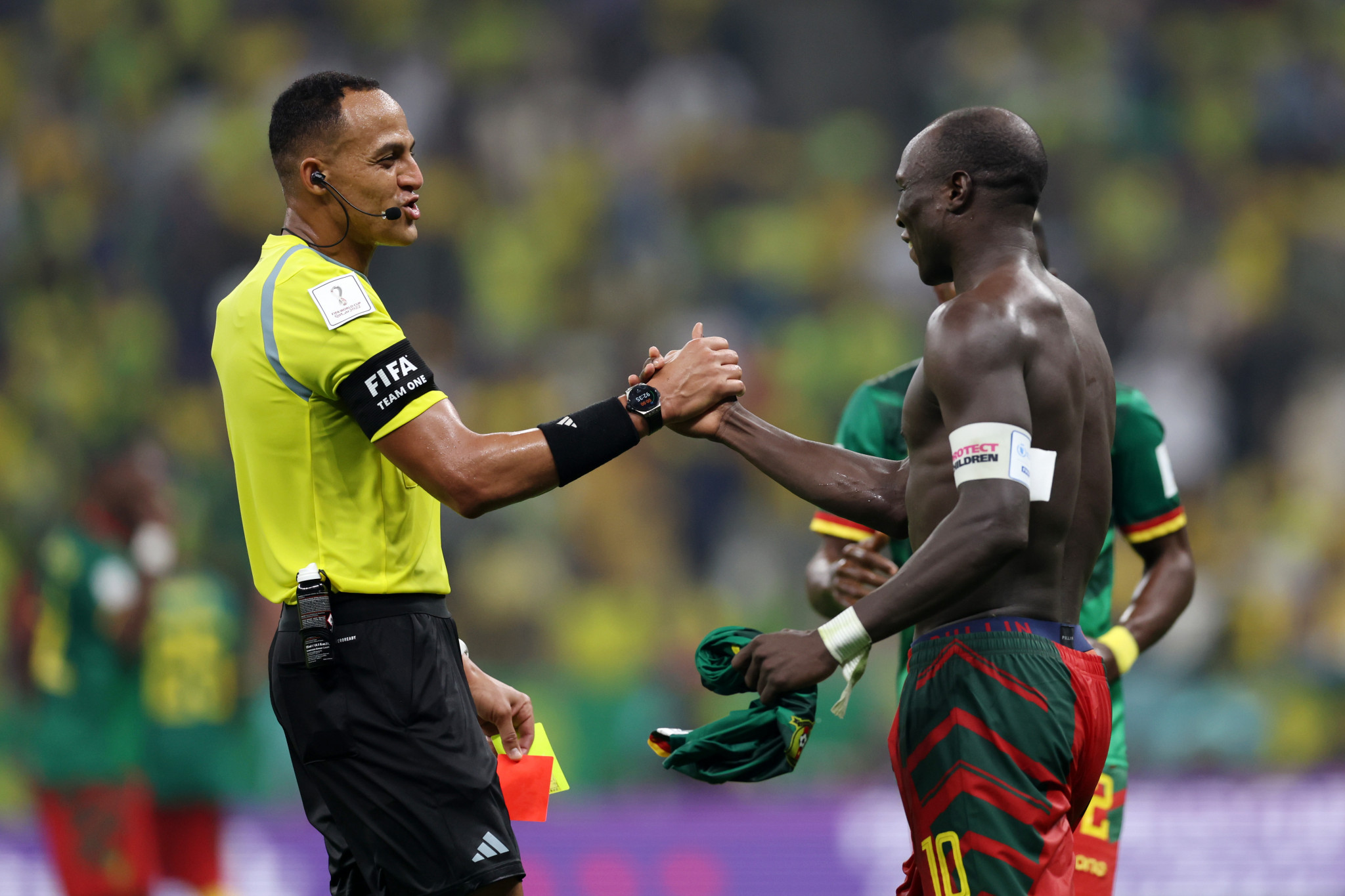 Vincent Aboubakar jovially shaking hands with the referee, who is about to send off the striker for a second yellow card after taking his shirt off ©Getty Images