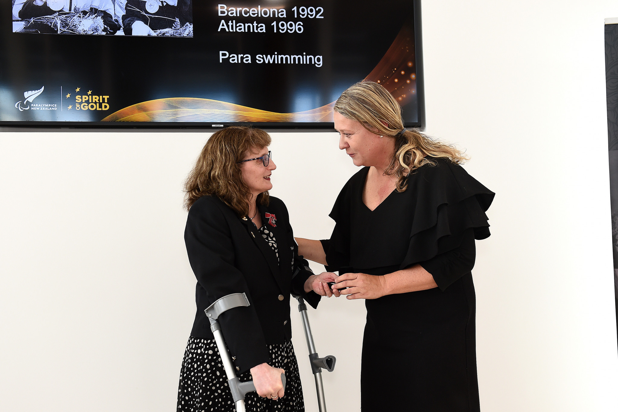 Paralympic swimmer Jenny Newsted, left, receives her commemorative pin from Fiona Allan at a PNZ ceremony ©Getty Images
