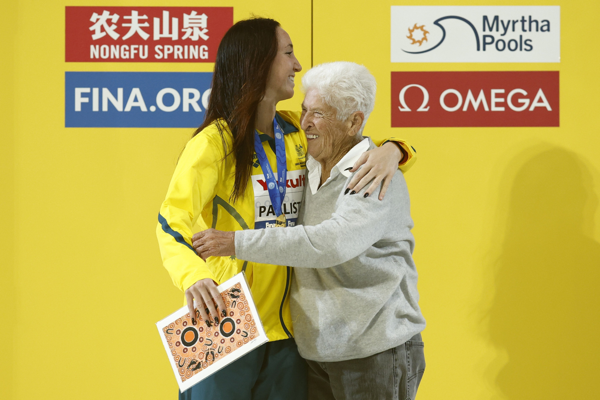 Australia's Lani Pallister celebrates with four-time Olympic champion Dawn Fraser on the podium after winning her fourth gold medal in Melbourne ©Getty Images