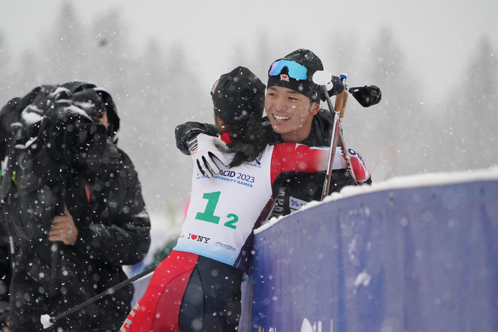 Cross-country skiiers Sobue and Hirose embrace after their victory in difficult conditions ©FISU