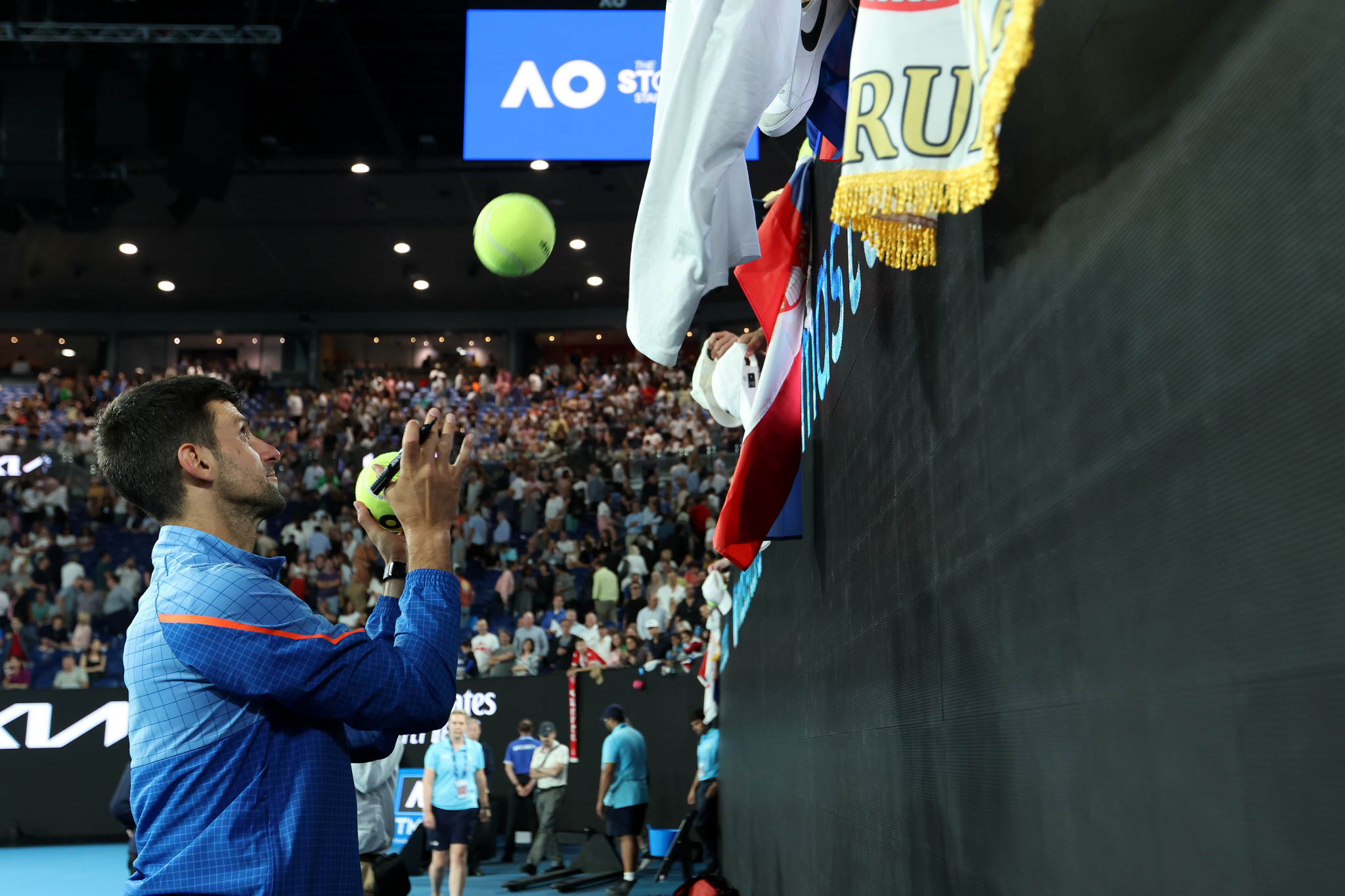 Novak Djokovic signing tennis balls for fans after his quarter-final match ©Getty Images